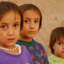 Three sisters, two of them twins, look somewhat anxiously into the camera, not quite knowing what to expect