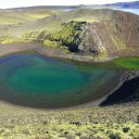 A-tiny-water-filled-crater-with-algae-growing-at-the-bottom