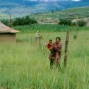 Friendly Zulu mother and child by their hut, known as a rondavel