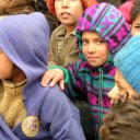 Children line up in the cold to get food and clothing in a donation center