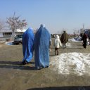 Two burka clad women hurry along a rural road. Although not mandatory anymore, many rural women still wear this all encompassing cloak