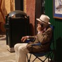 An elder Italian gallery owner at work