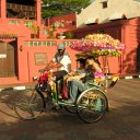 A highly decorated bicycle takes patrons on a cruise through the old town of Malacca
