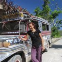 Woman standing next to Philippines famed Jeepneys