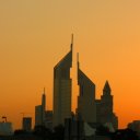 Sunset casts its golden glow and silhuettes two of the city's landmark buildings