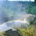 A rainbow forms at the base of the falls where the mighty Zambezi River collects itself again to continue its flow through a cataract and then on to the Indian Ocean