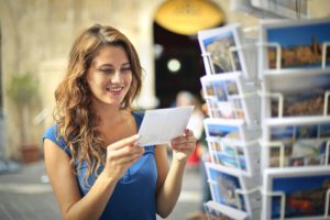 Happy woman choosing a postcard