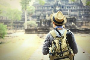 Young traveler wearing a hat with backpack and tripod - at Angkor Wat, Siem Reap, Cambodia