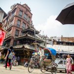 A rickshaw driving through an intersection in Kathmandu, Nepal