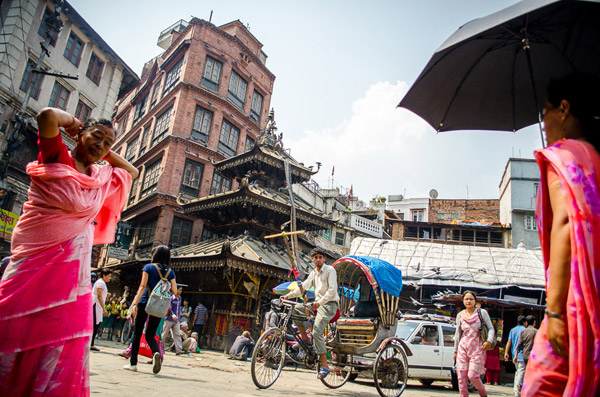 A rickshaw driving through an intersection in Kathmandu, Nepal