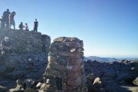 Busy summit cairn at the top of Scafell Pike