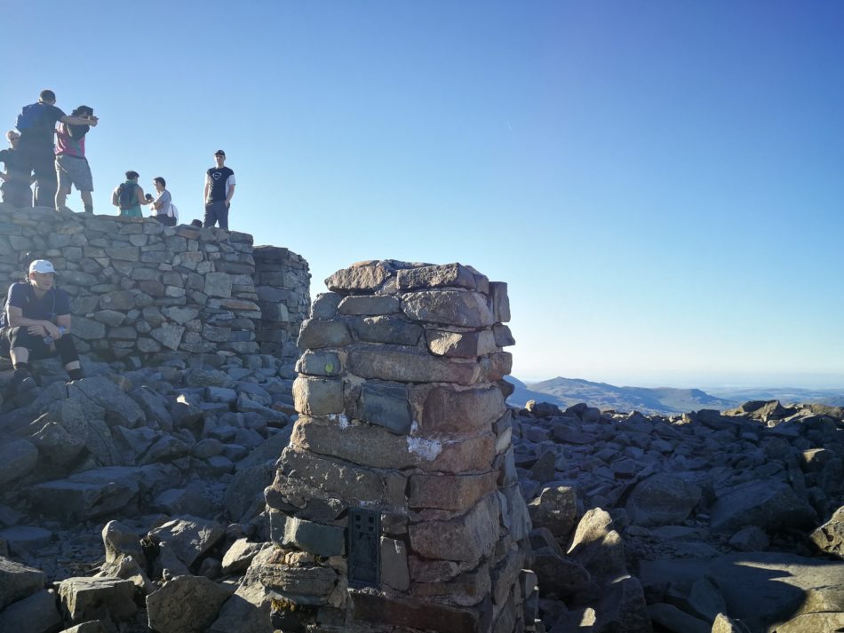 Busy summit cairn at the top of Scafell Pike