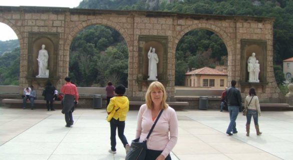 woman standing in front of white statue and mountain in montserrat spain