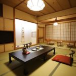 Traditional Japanese ryokan room with tatami floors, calligraphy scroll, and low table in Kochi, Japan