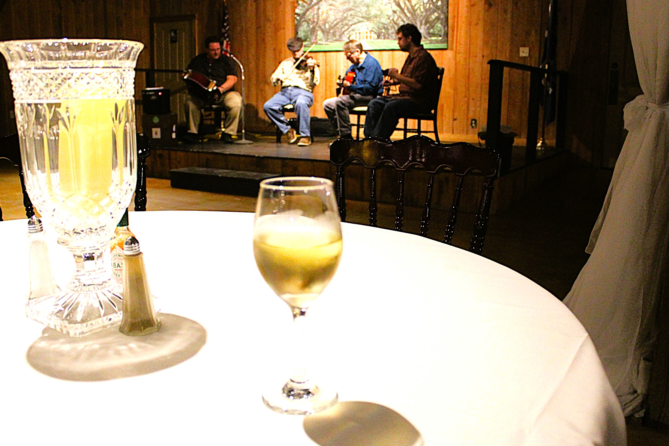 A glass of Chardonnay in foreground and a Cajun bank in background.
