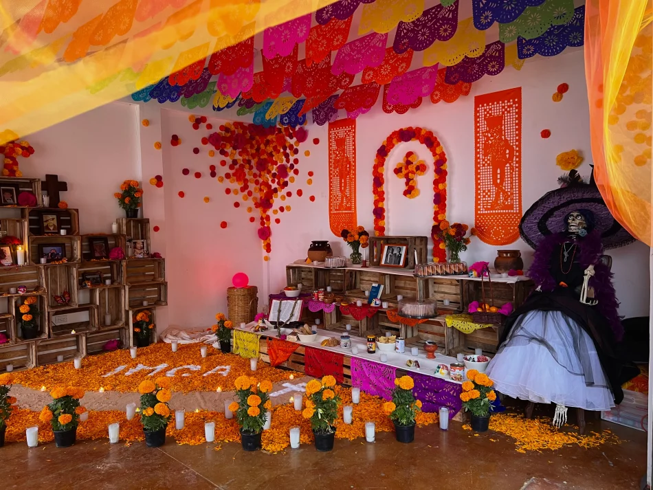 Hanal Pixán ofrenda in Cancun decorated with cempasúchil, candles, papel picado, photographs and food offerings.