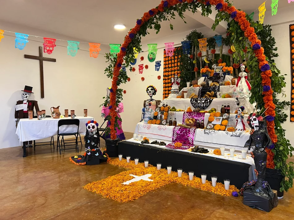 Hanal Pixán ofrenda in Cancun with marigolds, candles, food offerings, papel picado and Catrina-style figures.